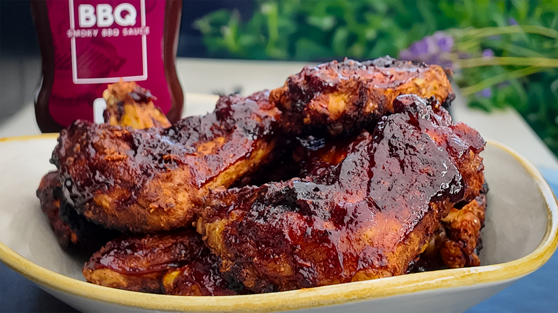 BBQ Chicken Wings glasiert mit FIVI BBQ Sauce in einer Schüssel, perfekt gegrillt und bereit zum Servieren