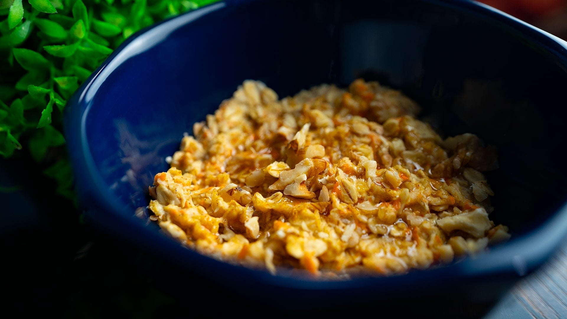 Karottenporridge in einer blauen Schale – gesundes Frühstück mit Haferflocken, Karotten und Walnüssen, perfekt für einen nährstoffreichen Start in den Tag.
