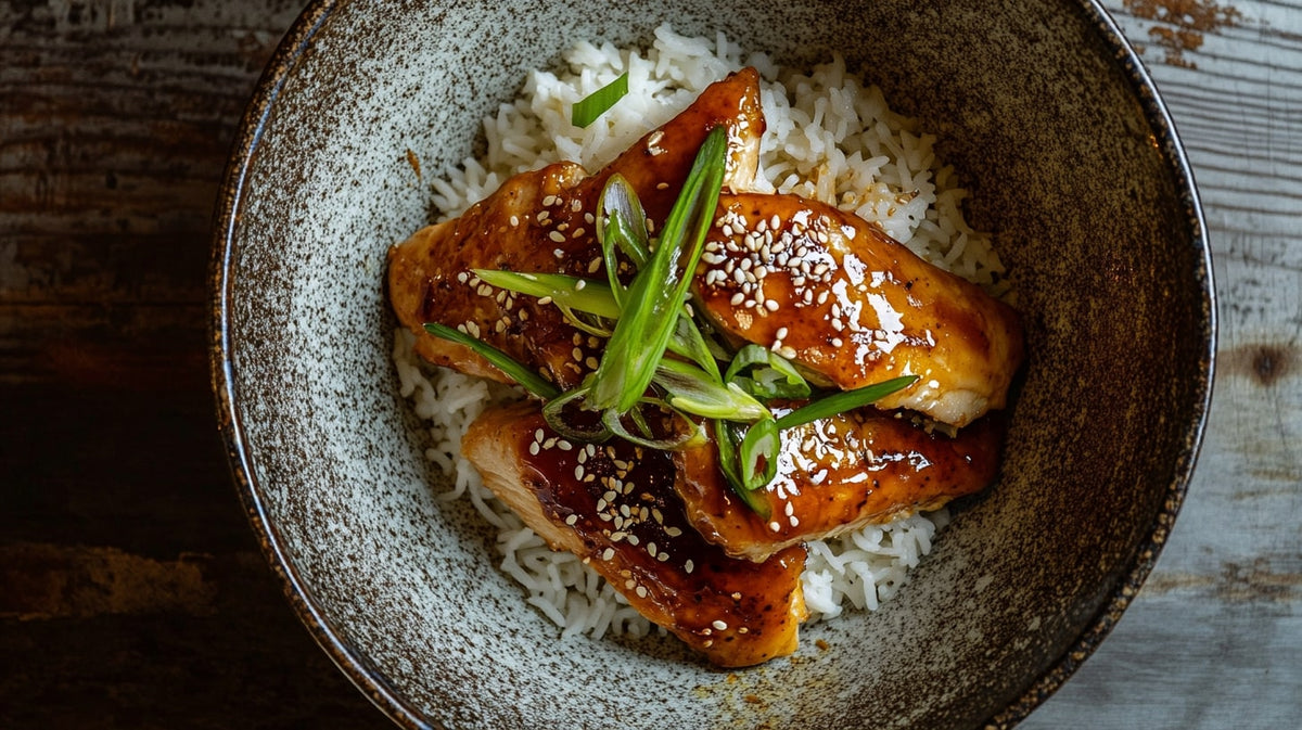 Chicken Teriyaki mit Reis in Schale serviert – saftiges Hähnchen in Teriyaki-Sauce, garniert mit Frühlingszwiebeln und Sesam