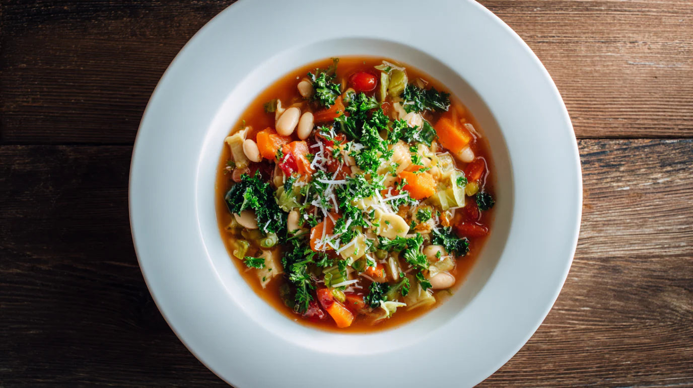 Minestrone Rezept – bunte italienische Gemüsesuppe mit Bohnen, Wirsing und Pasta in weißem Teller