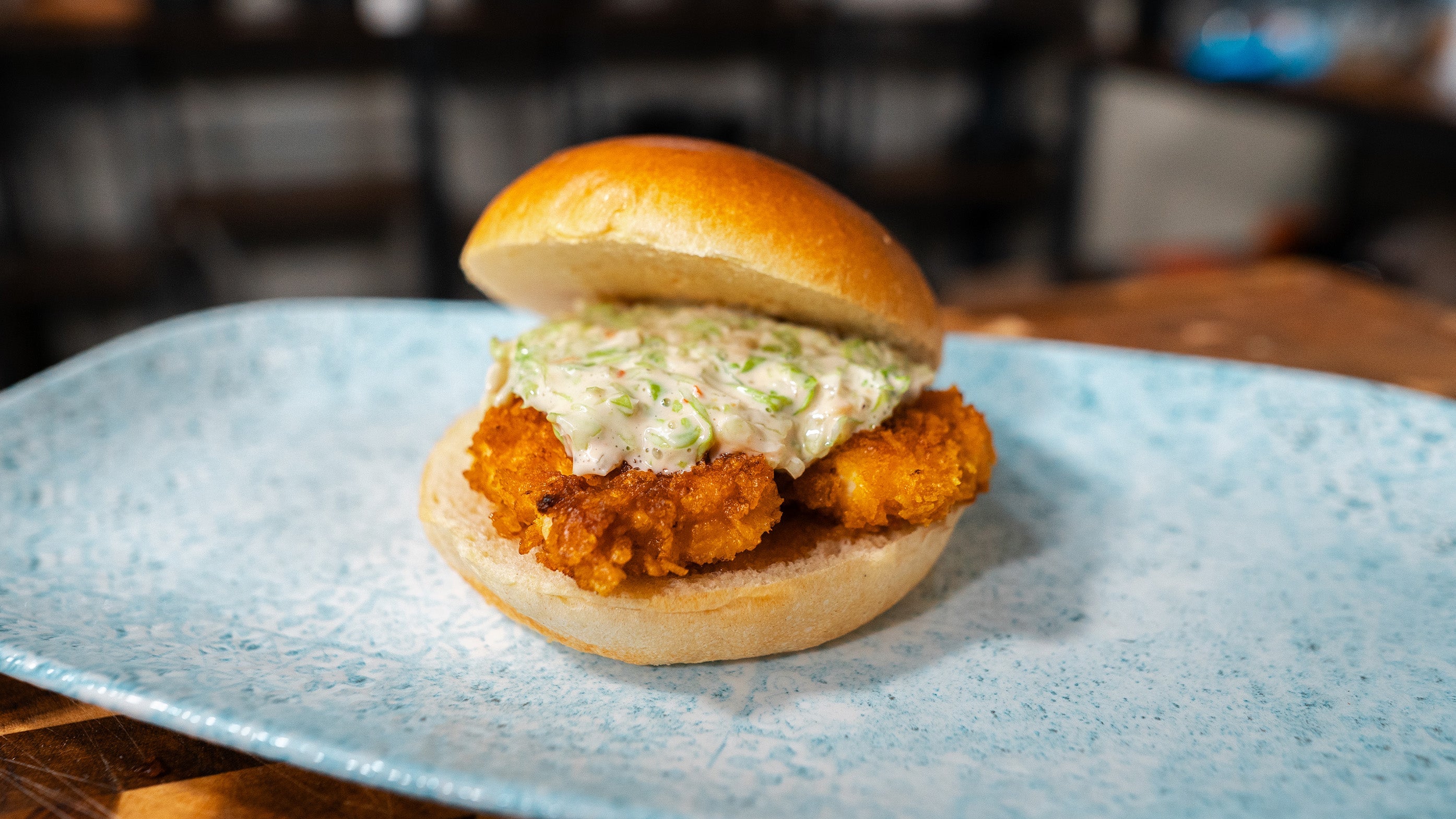 Rezept für Nuggetburger: Goldbraun frittierte Nuggets mit Krautsalat-Topping in einem weichen Burger-Bun.