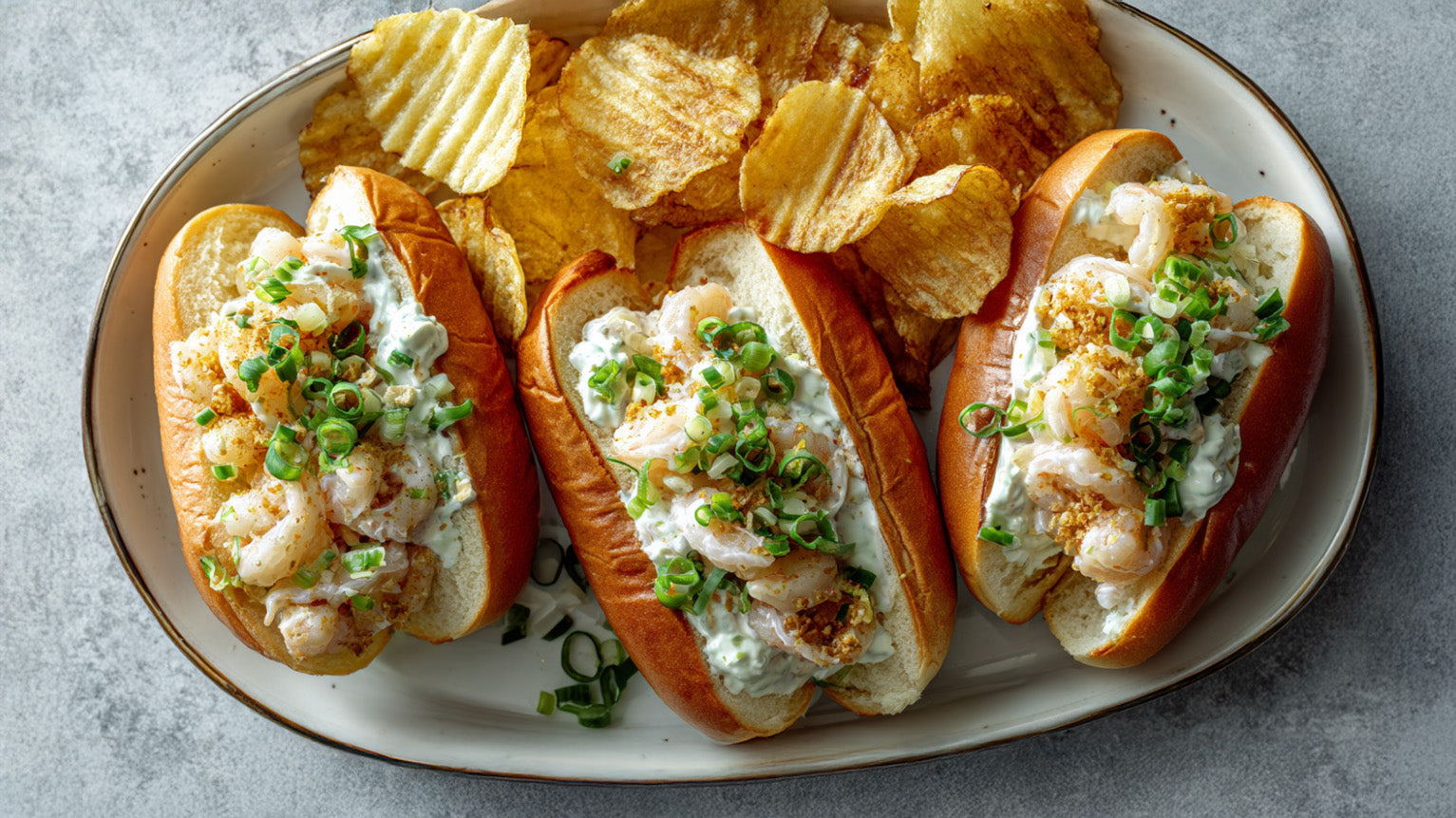 Shrimp Rolls Rezept – frische Garnelen in cremiger Sauce im Brötchen mit Sellerie und Chips als Beilage