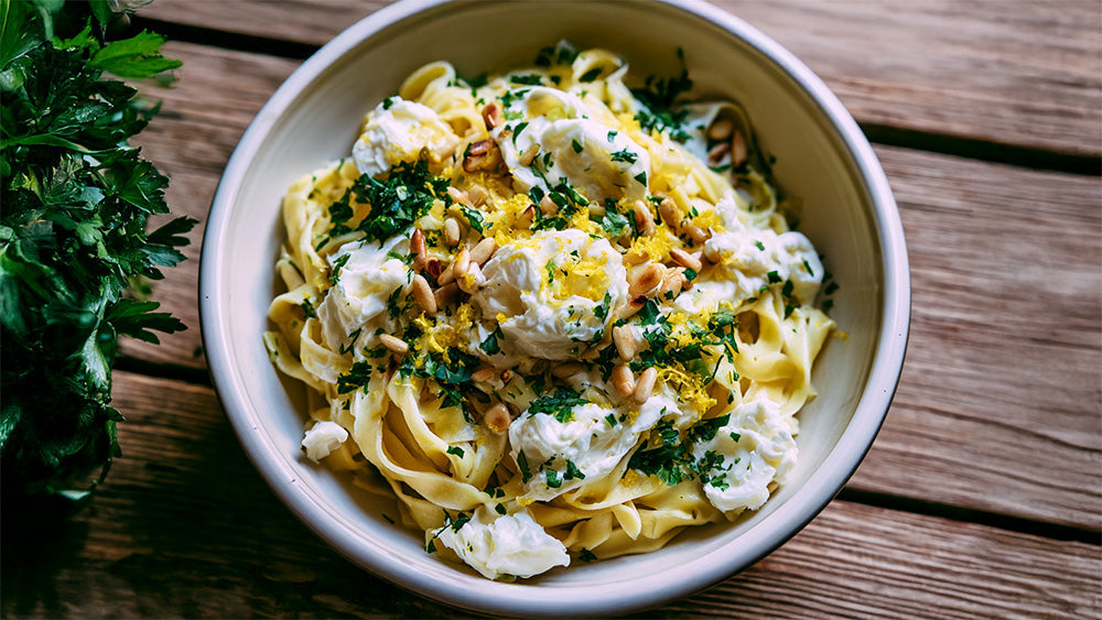 Pasta mit Mozzarella, Zitrone und Pinienkernen in einer Schale.Pasta mit Mozzarella, Zitrone und Pinienkernen in einer Schale.Pasta mit Mozzarella, Zitrone und Pinienkernen in einer Schale.