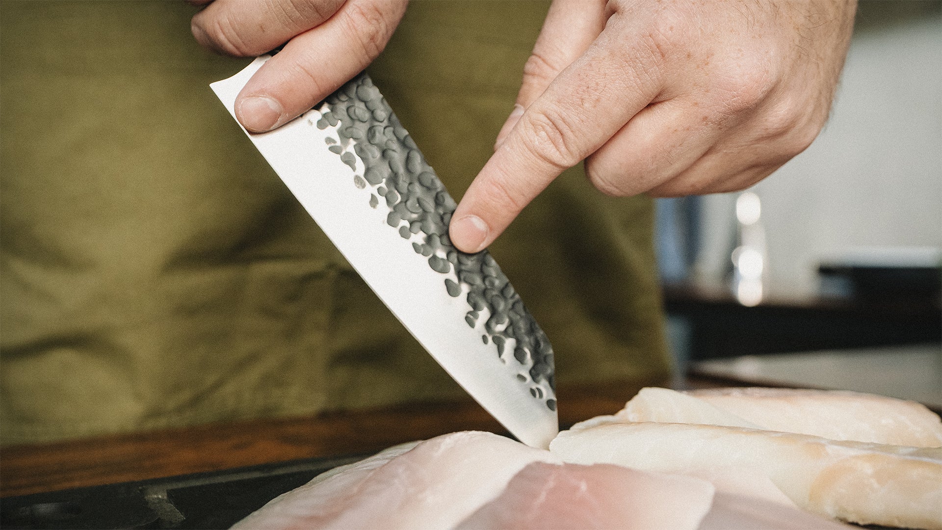 Das FIVI Messer "Yuki" wird von einem Mann genutzt, um Fisch zu schneiden.