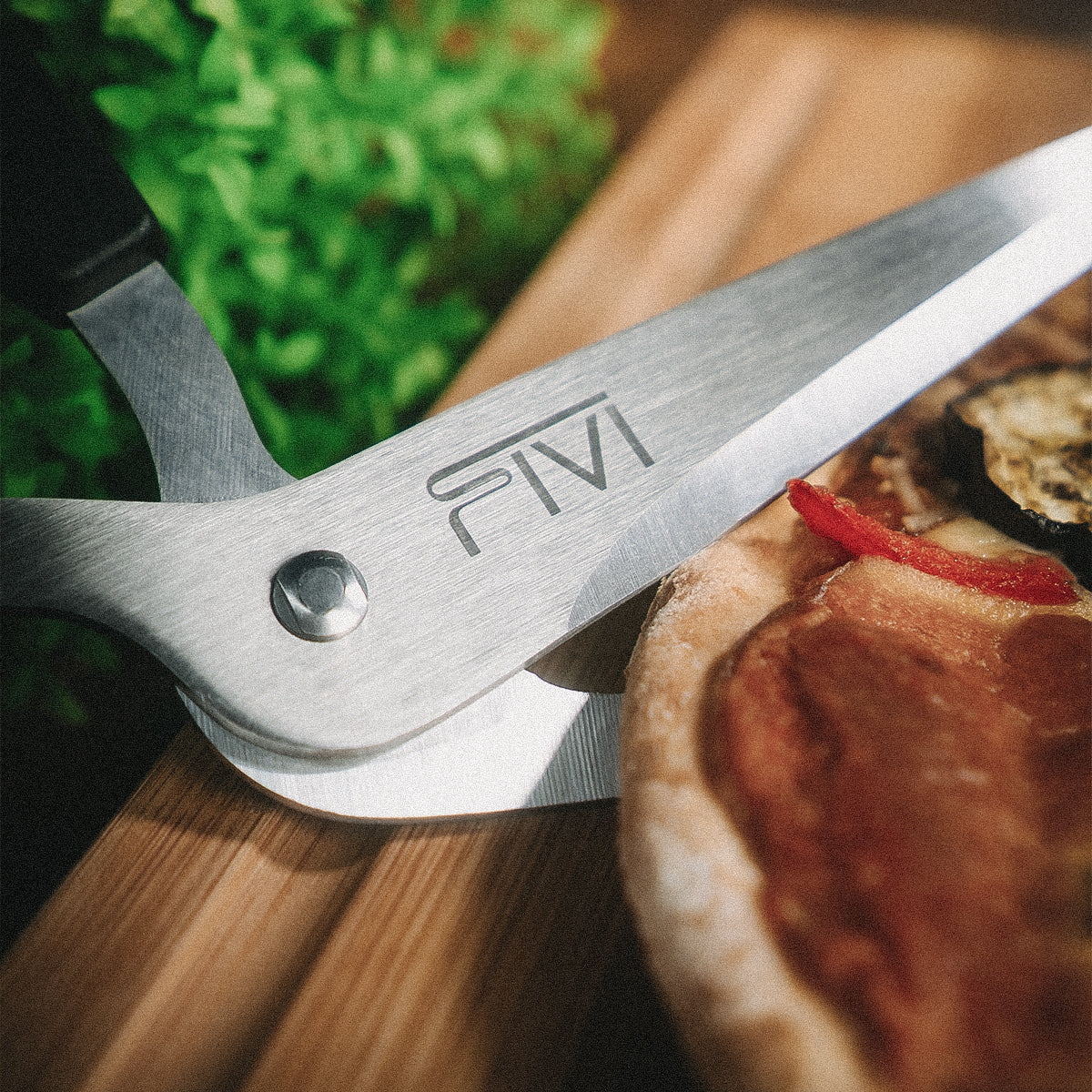 Die FIVI Pizzaschere PEPE schneidet einen Pizzarand.
