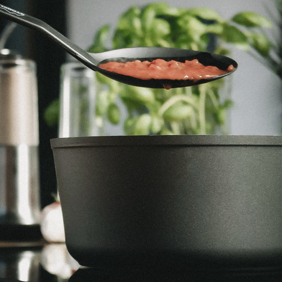 Ein Löffel Tomatensauce wird aus der FIVI Stielkasserolle SOPHIA genommen.