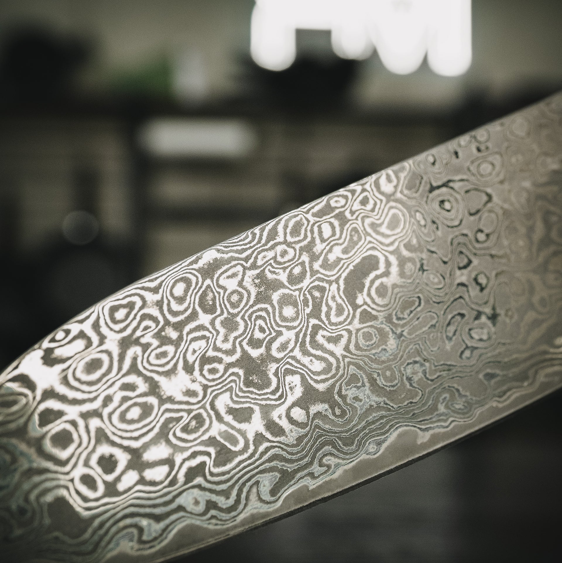 Makroaufnahme der einzigartigen Damast-Maserung auf der Klinge des Akira Küchenmessers.