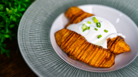 Knusprige Gitterkartoffeln mit Creme Fraiche und Frühlingszwiebeln serviert auf einem grauen Teller - Einfache und leckere Beilage mit FIVI Küchenzubehör