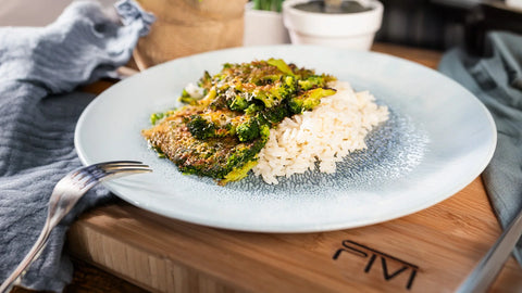 Smashed Brokkoli mit Parmesan und Reis auf einem blauen Teller – gesundes und knuspriges vegetarisches Gericht