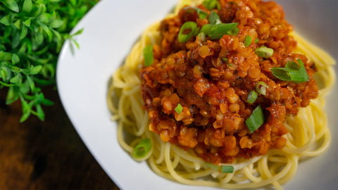 Vegane Linsenbolognese mit roten Linsen und Spaghetti, garniert mit Frühlingszwiebeln – proteinreich, gesund und einfach zuzubereiten.