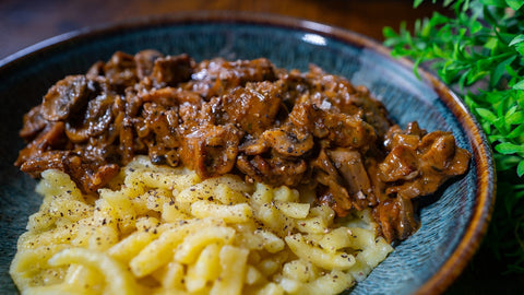 Veganes Geschnetzeltes mit cremiger Pilz-Sauce und Spätzle auf einem Teller – ein herzhaftes, pflanzliches Gericht für gesunden Genuss.