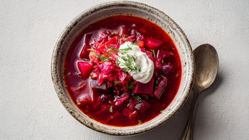 Borschtsch Rezept mit Roter Beete – leuchtend rote vegetarische Suppe mit Gemüse, Dill und cremigem Schmand in rustikaler Keramikschale