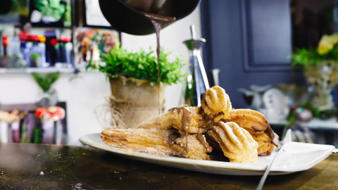 Churros mit Zimt-Zucker, serviert mit reichhaltiger Schokoladensauce, frisch zubereitet im FIVI Bratentopf KURT