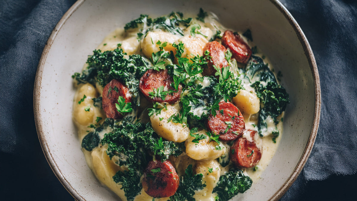 Gnocchi-Pfanne mit cremiger Blumenkohlsauce, veganer Salami und frischem Grünkohl – veganes Soulfood Rezept für ein schnelles Abendessen.