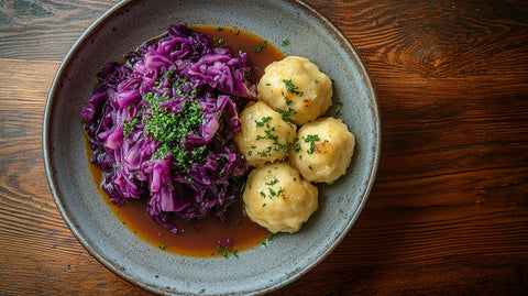 Kartoffelknödel mit Rotkohl auf rustikalem Teller serviert – festliches Weihnachtsgericht mit Kartoffelknödeln und würzigem Rotkohl, perfekt für die Winterzeit