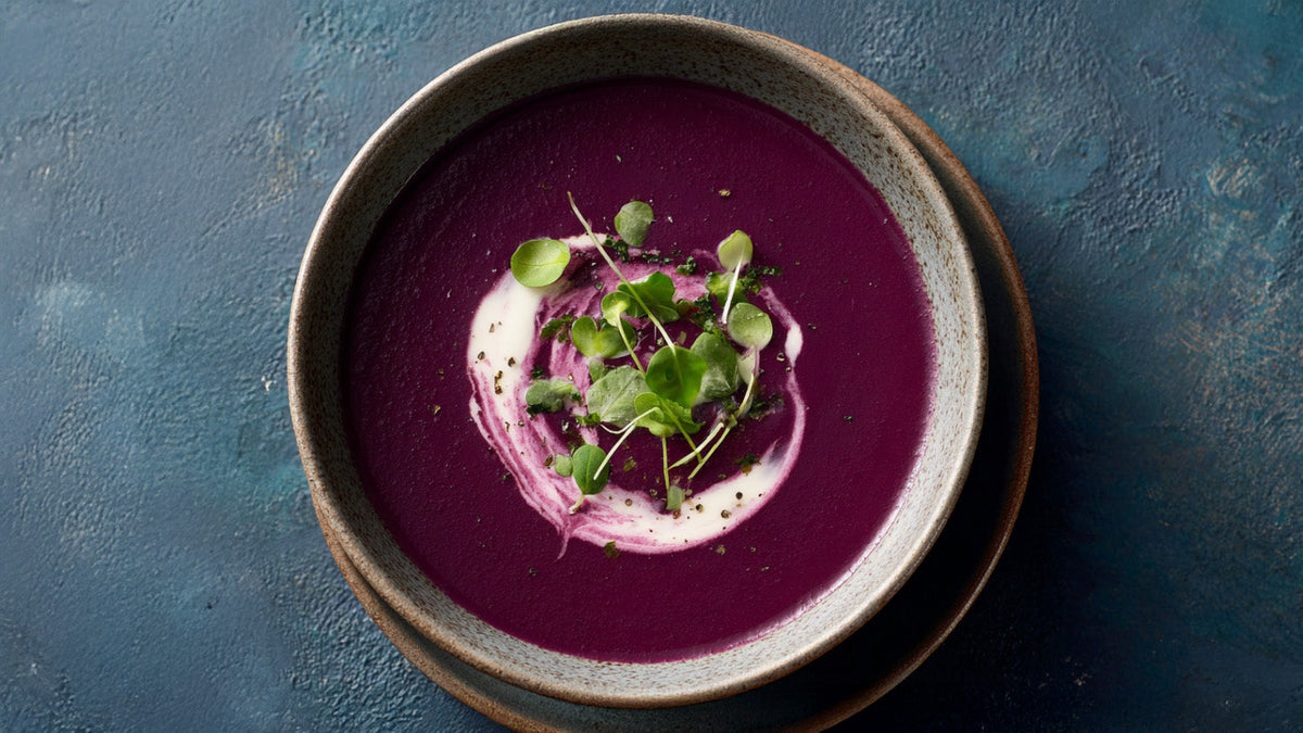 Rotkohlsuppe low calorie in Keramikschale, cremig püriert, mit Hafersahne-Swirl und frischer Gartenkresse serviert
