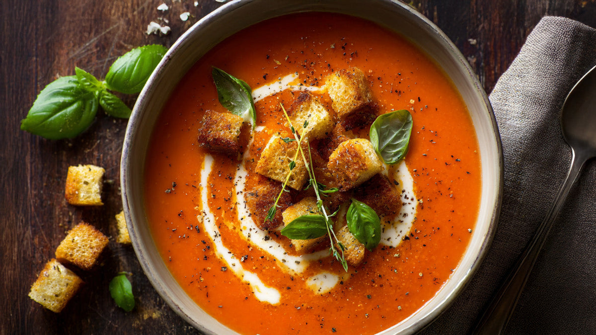 Tomatensuppe mit Knoblauch-Croutons – cremige Suppe mit frischem Basilikum und goldbraunen Croutons in Schale serviert
