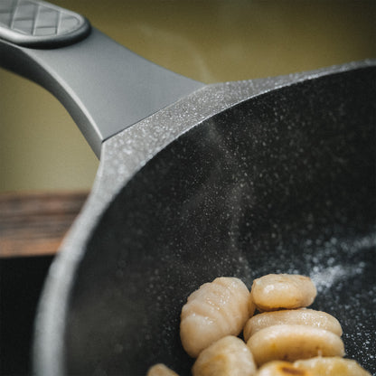 Nahaufnahme des Pfannenrands und des strukturierten Griffs zur Verdeutlichung der hochwertigen Materialverarbeitung.