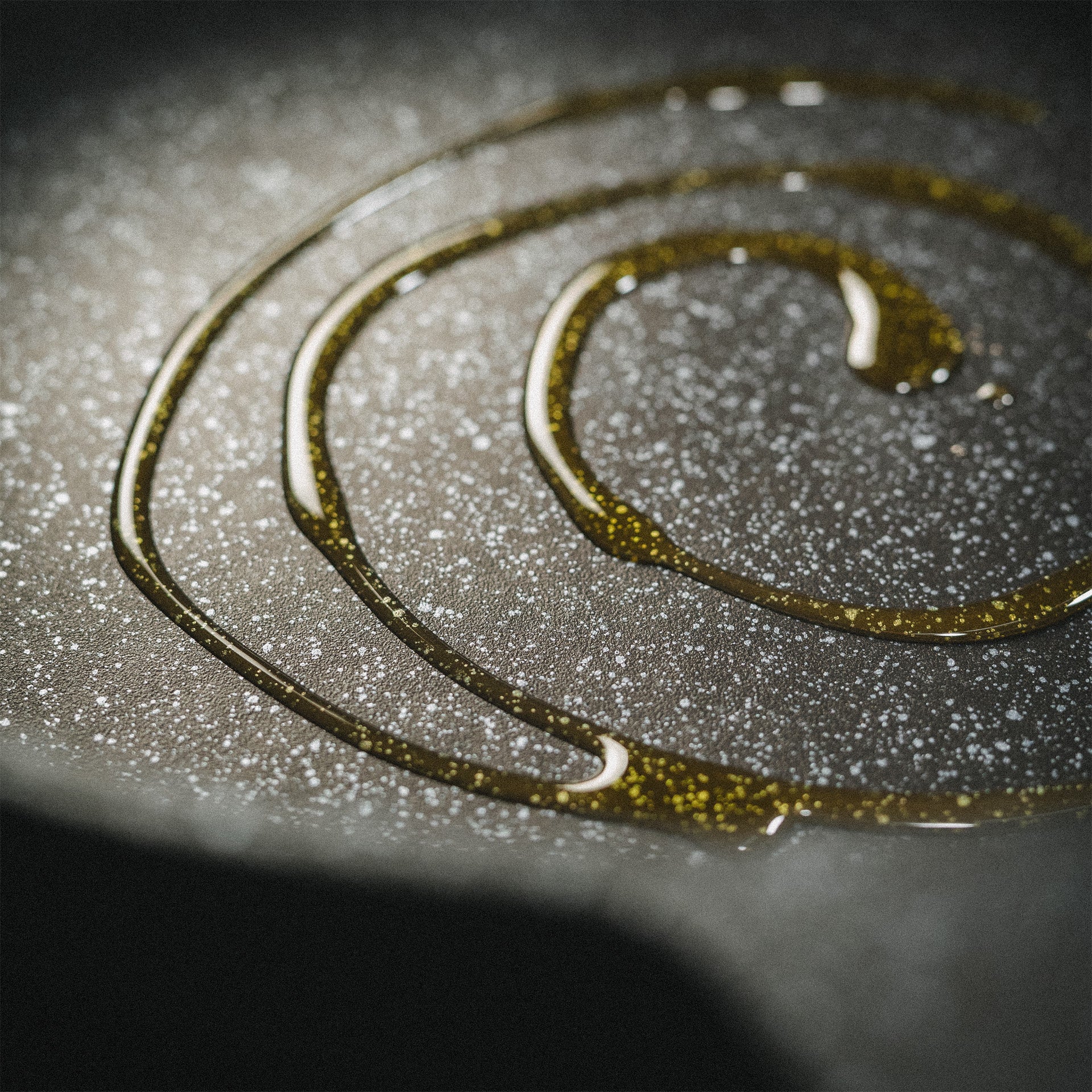 Detailaufnahme von Olivenöl in der beschichteten Pfanne Almer zur Darstellung der fettarmen Brat-Eigenschaften und Oberflächenstruktur.