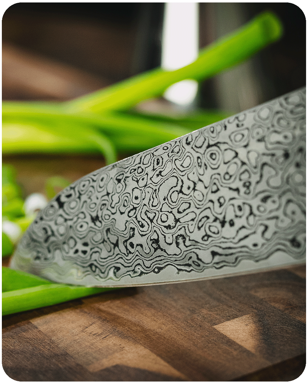 Detailansicht der charakteristischen Maserung einer Damaststahl-Klinge in der Küche.