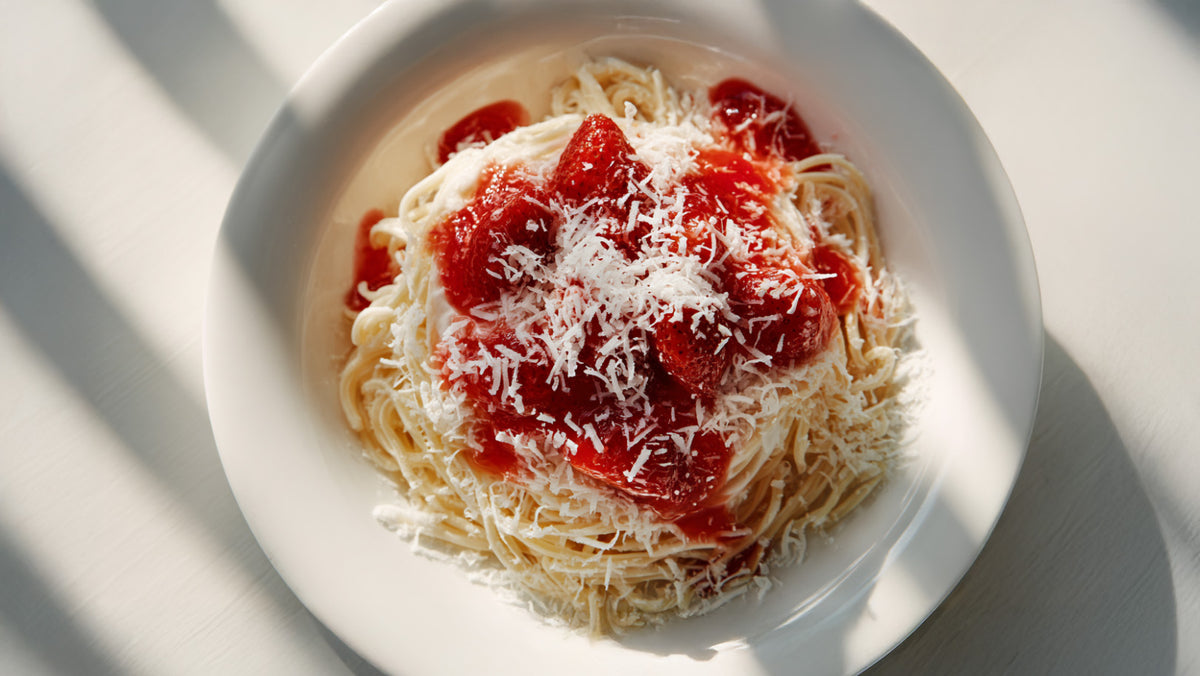 Spaghetti-Eis angerichtet mit Vanilleeis, frischer Erdbeersauce und geriebener weißer Schokolade – schnell zubereitet wie aus der Eisdiele